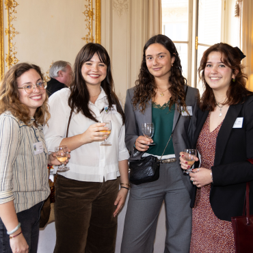 Four UCD alumnae at an Alumni Reception in Paris, posing for a photo, smiling at the camera.